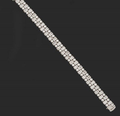 Lot 399 - An 18 Carat White Gold Diamond Bracelet, the staggered baguette cut and round brilliant cut...