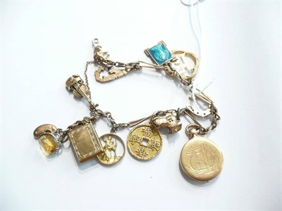 Lot 77 - A gold charm bracelet hung with thirteen charms
