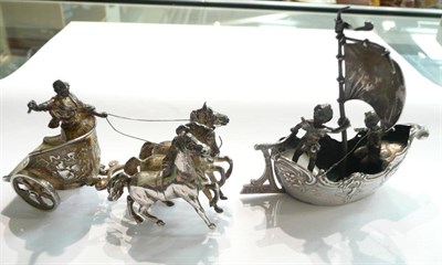 Lot 95 - Silver table ornament modelled as a ship with putto together with another figure with a chariot and