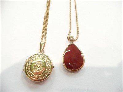 Lot 375 - A double sided mother-of-pearl and cornelian pendant on chain and a locket on chain