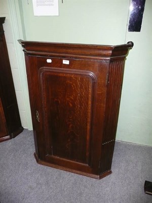 Lot 665 - George III oak hanging corner cupboard