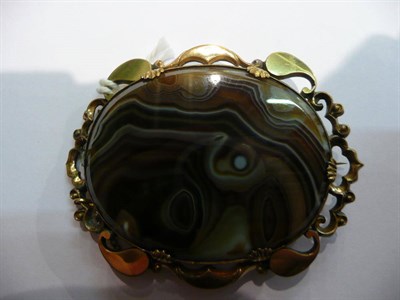 Lot 76 - An oval banded agate in a fancy brooch frame