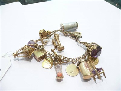 Lot 85 - A charm bracelet, hung with 17 charms, 63.4g approximately