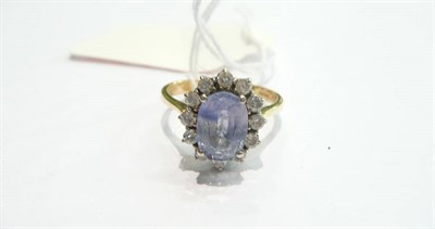 Lot 394 - Lady's diamond cluster ring set with a blue sapphire