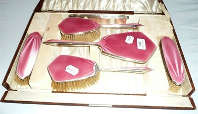 Lot 446 - A cased pink enamel and silver dressing set