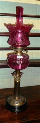 Lot 533 - Cranberry glass and brass oil lamp and shade