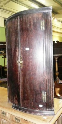 Lot 614 - Georgian oak bow-fronted corner cupboard