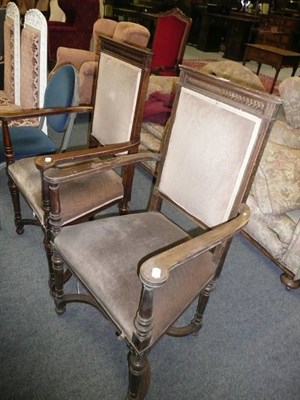 Lot 665 - A pair of Continental mahogany elbow chairs with shaped cross framed stretcher