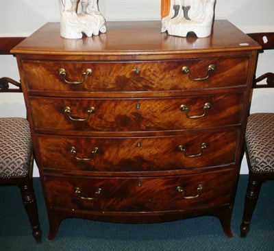 Lot 687 - Late George III bow-fronted chest of four long drawers in flame mahogany