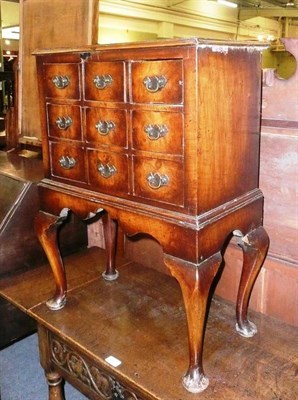 Lot 704 - Walnut cross banded nine draw chest on stand with cabriole legs