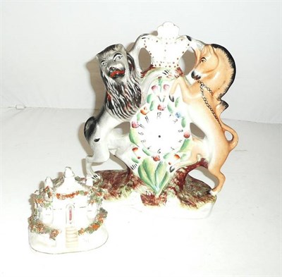 Lot 67 - A Staffordshire lion and unicorn clock group and a cottage