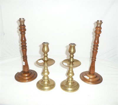 Lot 284 - A pair of brass candlesticks and a pair of wood candlesticks