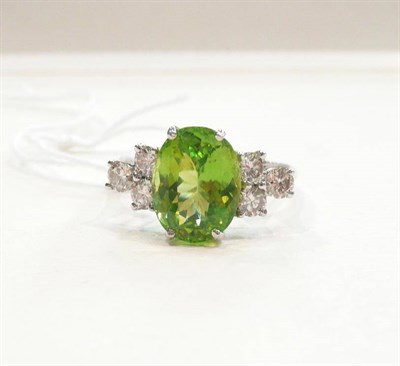 Lot 319 - A 14 carat white gold, peridot and diamond ring