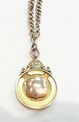 Lot 395 - A 9ct shield on a worn chain