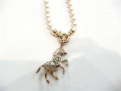 Lot 400 - A 9ct gold gem set horse on a simulated pearl necklace