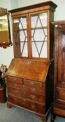 Lot 710 - A late George III oak bureau bookcase, the upper section enclosed by glazed panelled door, the base