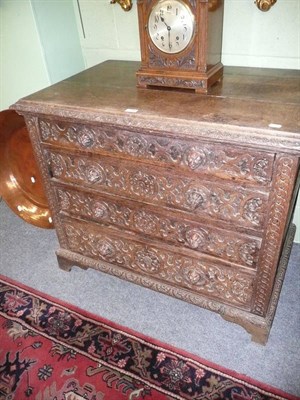 Lot 730 - Carved oak four height chest of drawers with lion mask handles