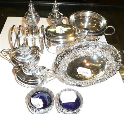 Lot 177 - A silver mustard pot, two salts, two pepperettes, a small basket, a toastrack, two handled bowl and