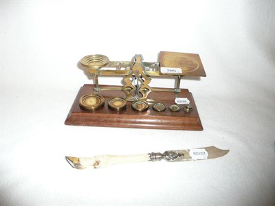 Lot 285 - Brass postal scales with weights and a hoof handled and mother of pearl paper knife (a.f.)