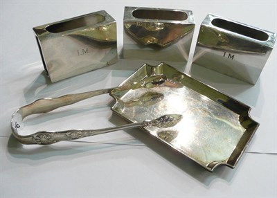 Lot 98 - Three silver match box holders, tongs and a pin dish