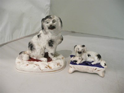 Lot 143 - A Staffordshire porcelaneous spaniel and an inkwell (2)