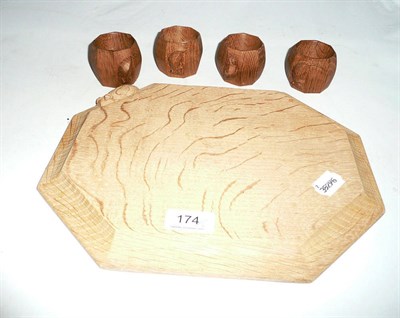 Lot 174 - A Robert 'Mouseman' Thompson oak breadboard and a set of four 'Mouseman' napkin rings