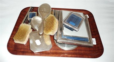 Lot 11 - Mappin & Webb silver photograph frame, four silver ashtrays, silver mounted brushes, mirror and...