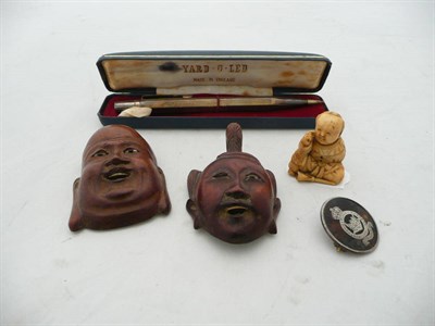 Lot 406 - A Japanese ivory netsuke as a boy; two small hardwood masks; a tortoiseshell and silver pique...