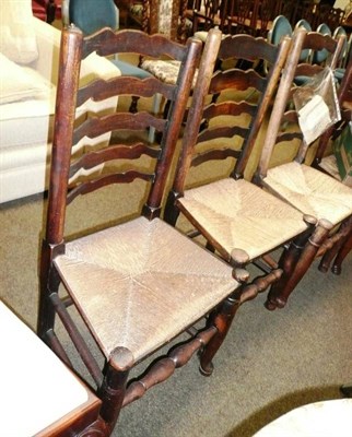 Lot 650 - Harlequin set of four elm ladder-back chairs