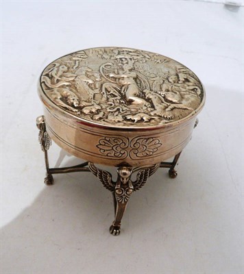 Lot 273 - A silver circular box on four supports embossed with animals