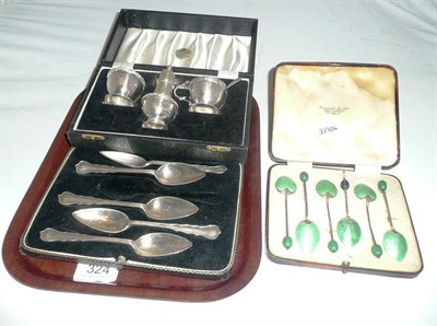 Lot 324 - A cased silver condiment set, five cased silver grapefruit spoons and a set of cased enamel...