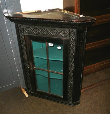 Lot 486 - A glazed and carved oak corner cupboard