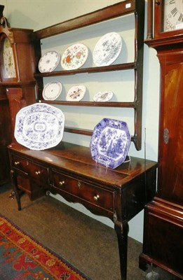 Lot 616 - A small George II oak dresser and an associated wall-mounted Delft rack