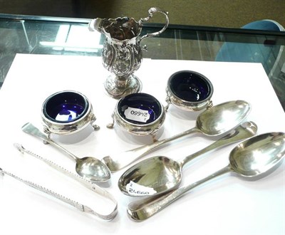 Lot 65 - Georgian silver cream jug, three circular salts with blue liners, set of three tablespoons,...