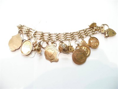 Lot 86 - A gate bracelet hung with seven shields and six charms
