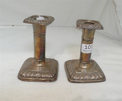 Lot 101 - A matched pair of gadrooned silver candlesticks
