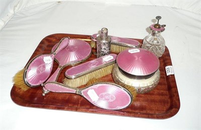 Lot 153 - A seven piece pink enamel dressing set, a scent bottle holder and a comb holder (8)