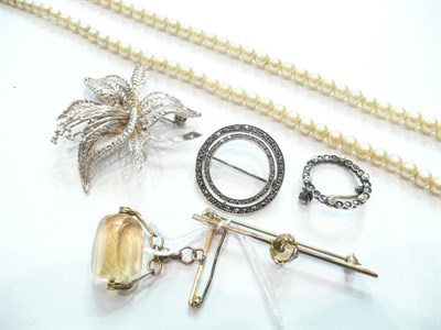 Lot 180 - A citrine set bar brooch, a citrine drop brooch, three other brooches and stand of simulated pearls