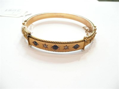 Lot 212 - A bangle set with sapphires and diamonds