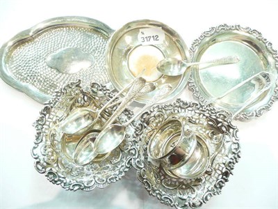 Lot 341 - A pair of silver pierced heart shaped baskets, three silver pin trays, a pair of silver napkin...