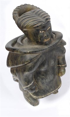 Lot 1179 - A Canadian Inuit Carved Green Soapstone and Bone Inlaid Figure of a Hunter, 20th century, standing