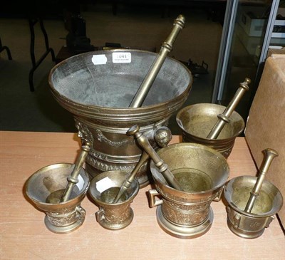 Lot 1041 - Six Brass Pestles and Mortars, including a large mortar with lambrequin mask handles and cast...