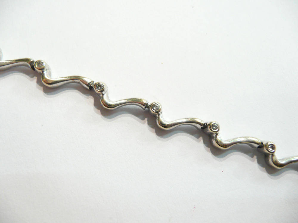 Lot 70 - A wavy diamond set bracelet