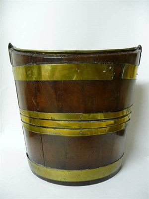 Lot 1221 - A George III Mahogany Brass Bound Peat Bucket of elliptical form with overhead swing handle,...