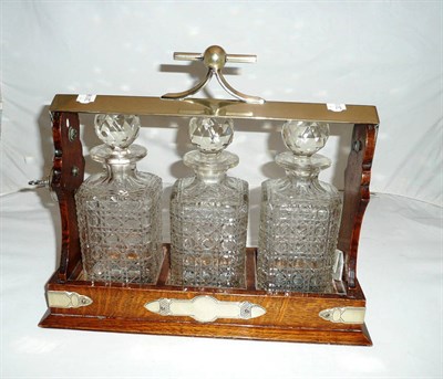 Lot 32 - Oak tantalus with three decanters