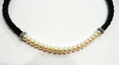 Lot 324 - A strand of pearls on a leather necklace