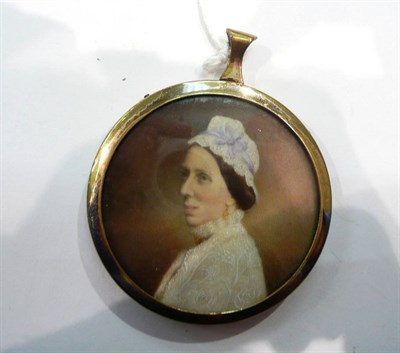 Lot 455 - A miniature portrait of a lady, circular, in a gold plated pendant frame and in a fitted easel back