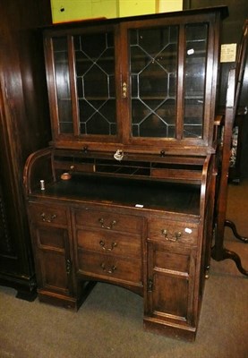 Lot 696 - An oak roll top desk with glazed mahogany bookcase