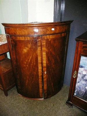 Lot 706 - Georgian mahogany bow-front corner cabinet