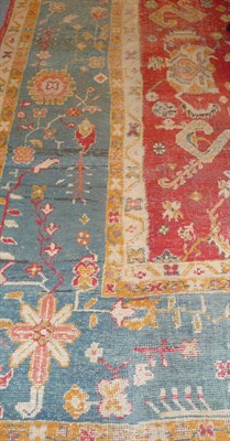 Lot 1379 - A Turkey Carpet, the bright red field with allover flowerheads, palmettes, etc, within a blue...